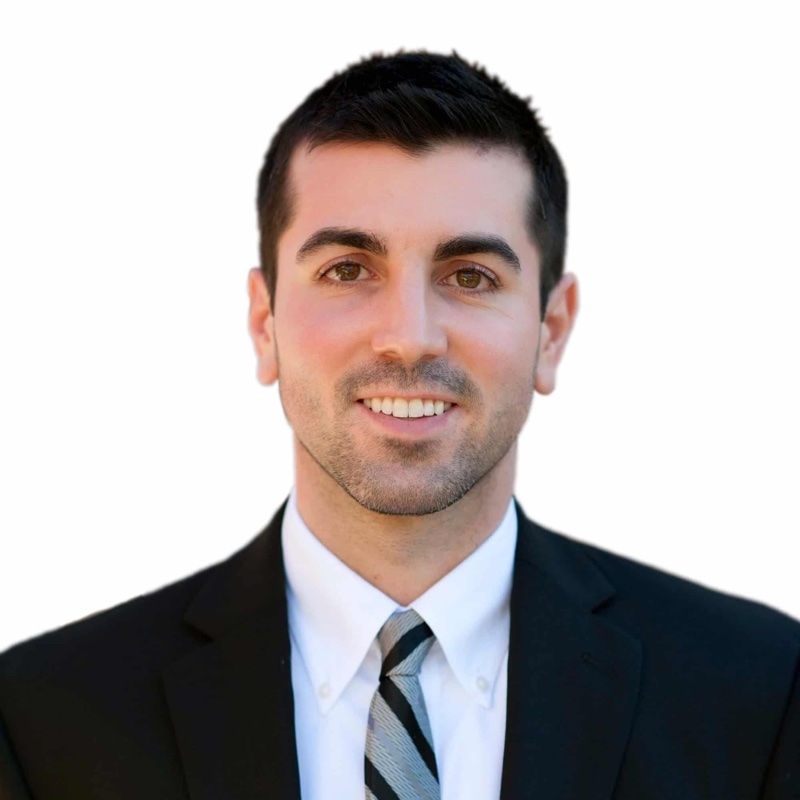 Dr. Kevin Ivory, audiologist, smiling in a dark suit and striped tie